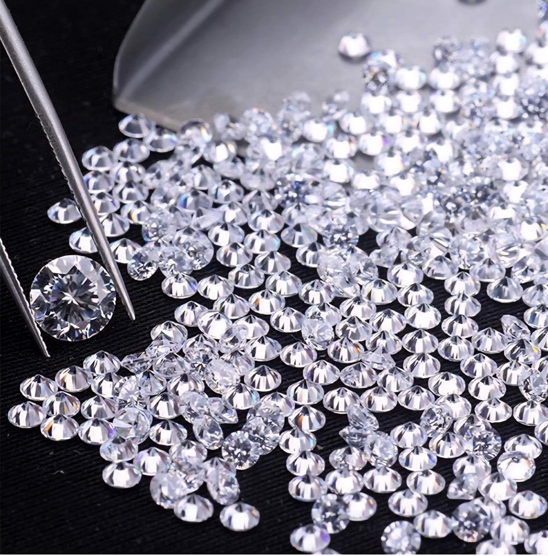 Round brilliant melee diamonds inspected with tweezers